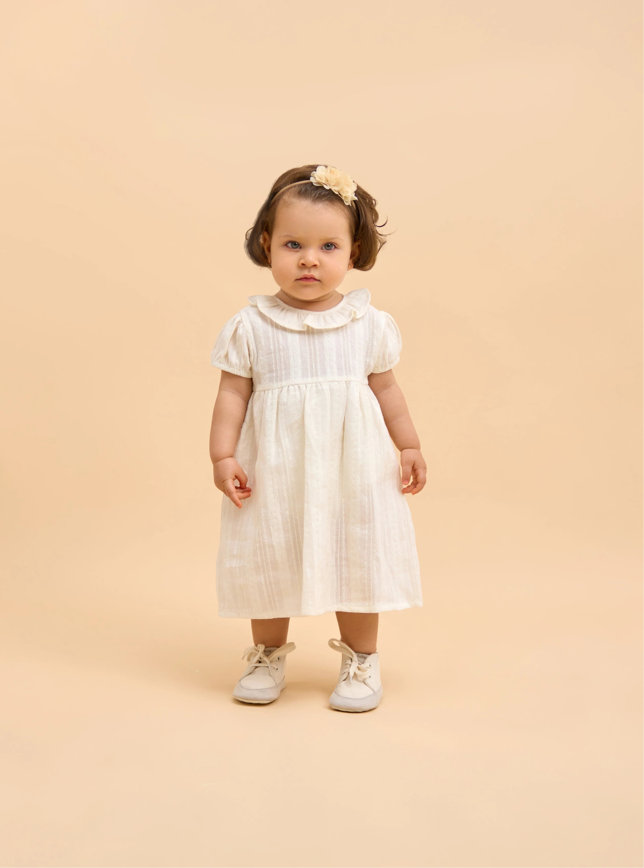 Niña dando sus primeros pasos con calzado respetuoso infantil que acompaña el movimiento natural del pie.