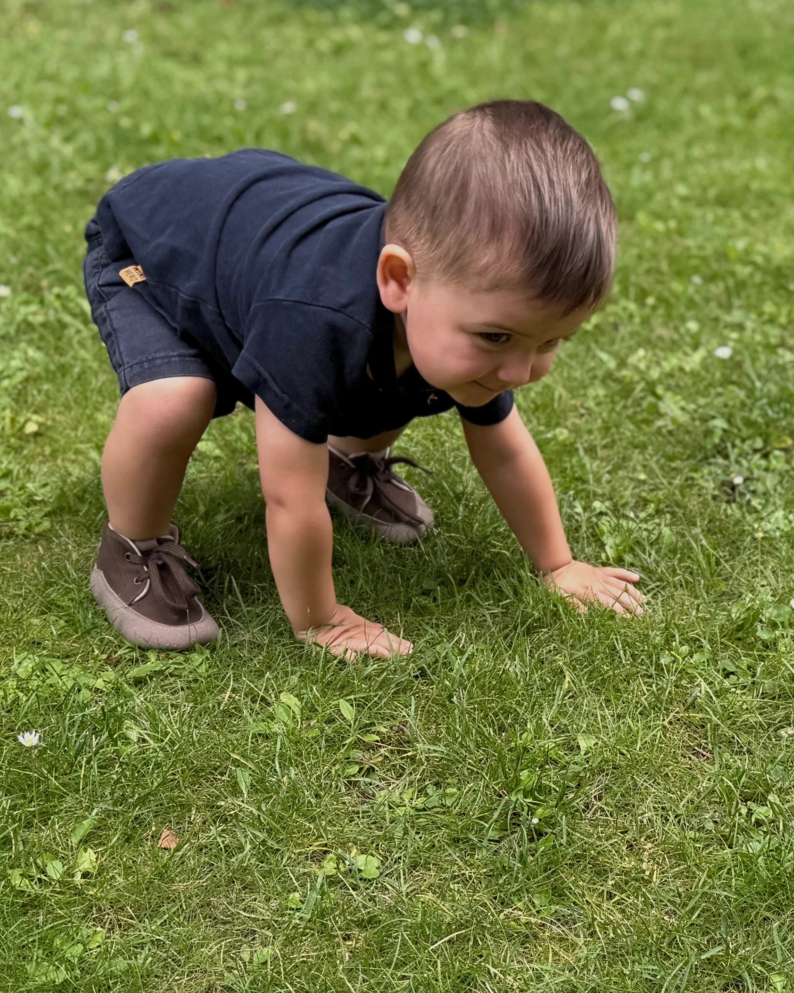 Bebé con calzado infantil respetuoso explorando al aire libre.