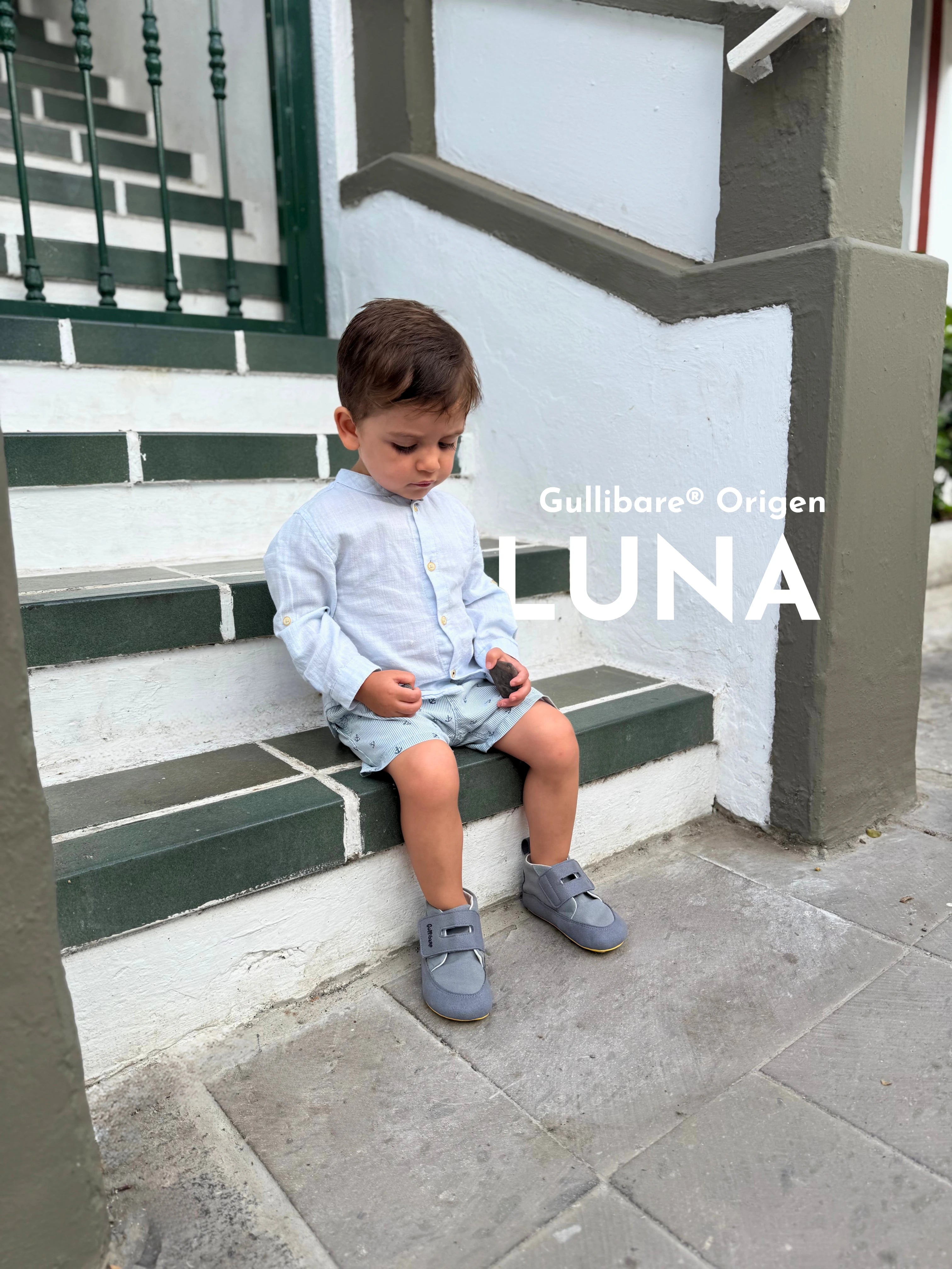Niño pequeño sentado en unas escaleras usando zapatos respetuosos Gullibare modelo Luna