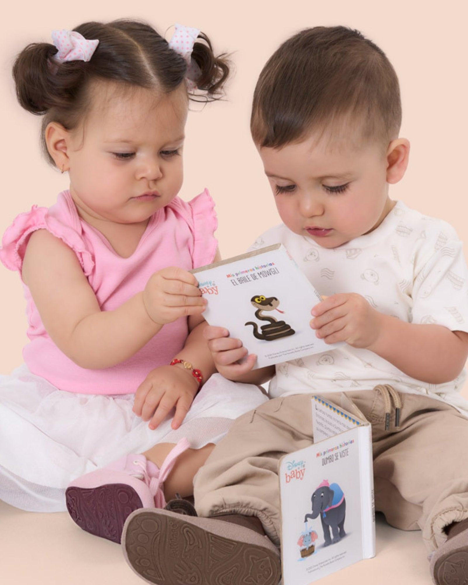 Dos niños pequeños sentados en el suelo descubren con curiosidad unas boticas Gullibare®, símbolo de los primeros pasos con libertad y cuidado natural.