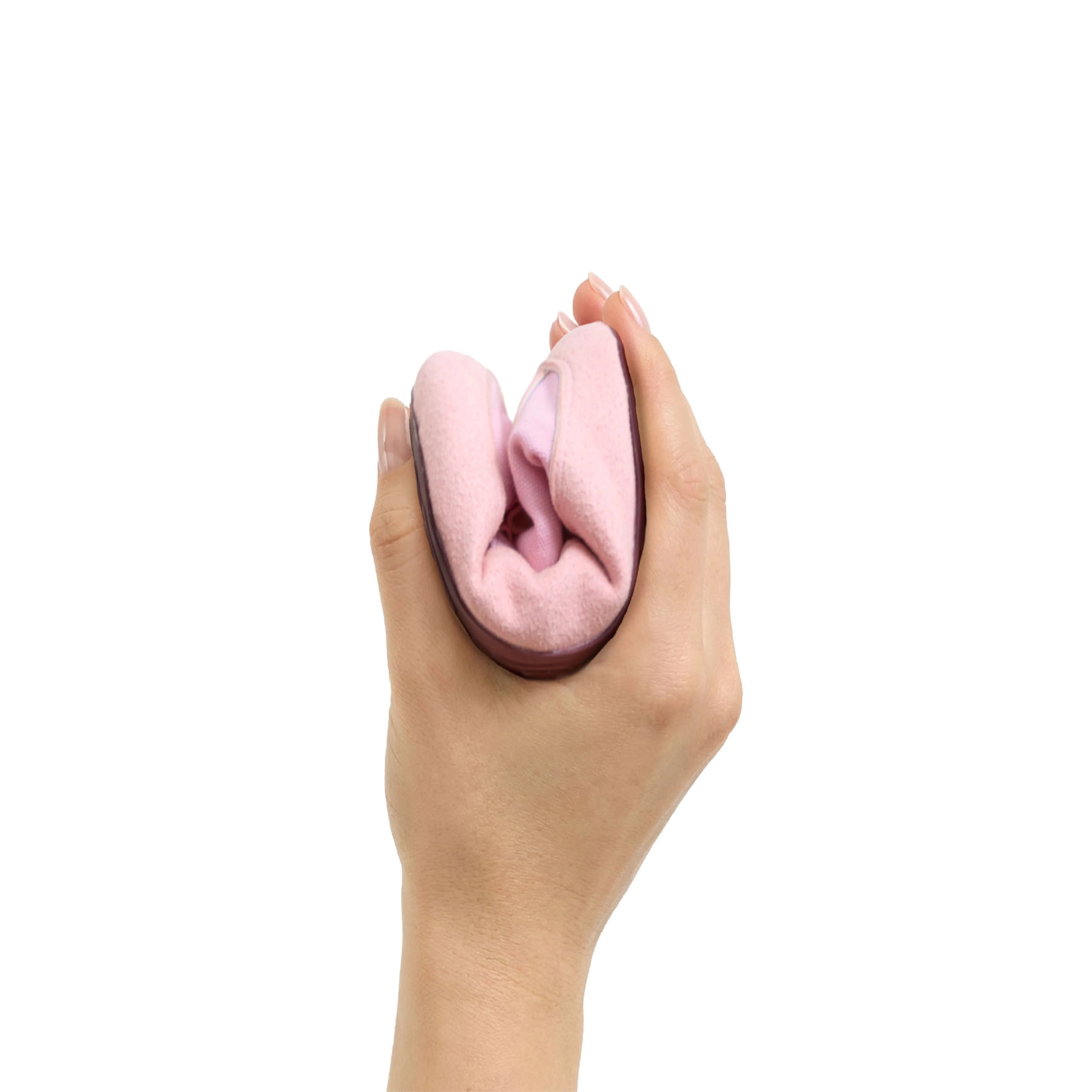 Calzado respetuoso Gullibare para bebés en color rosa, plegado en la mano para mostrar su flexibilidad, suavidad y adaptación natural al movimiento del pie infantil.
